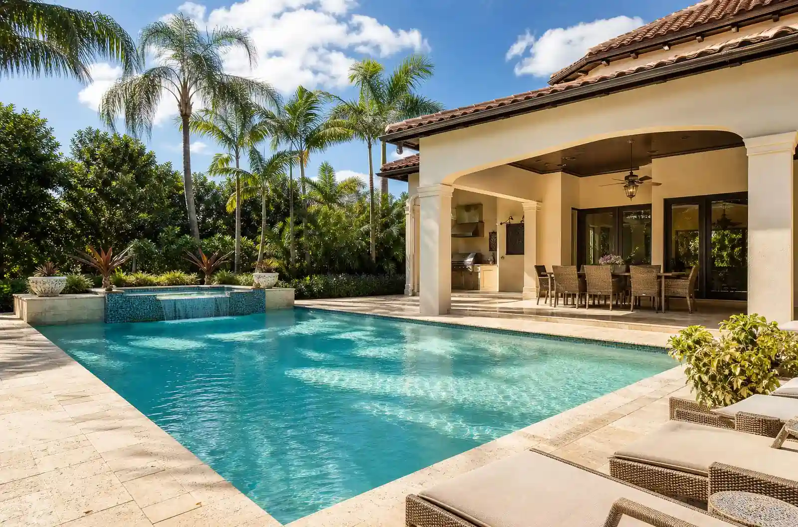 Luxury Boca Raton backyard pool and covered patio with tropical landscaping